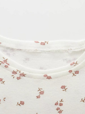 White baby dress with pink floral print and ruffled neckline.