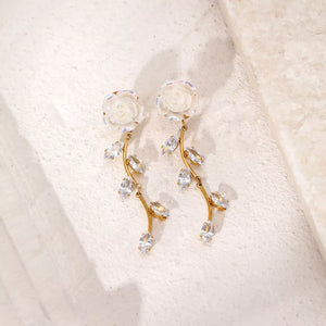 white earrings featuring drop design and floral