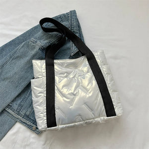Padded nylon tote bag in silver with exterior pockets and black straps.