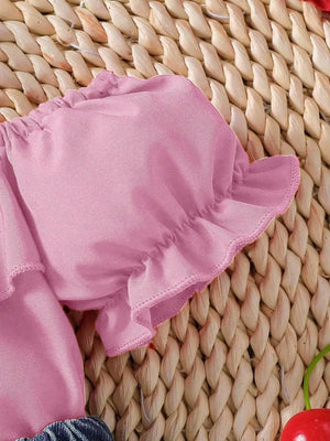 Pink cotton baby top with ruffled sleeves and trim.