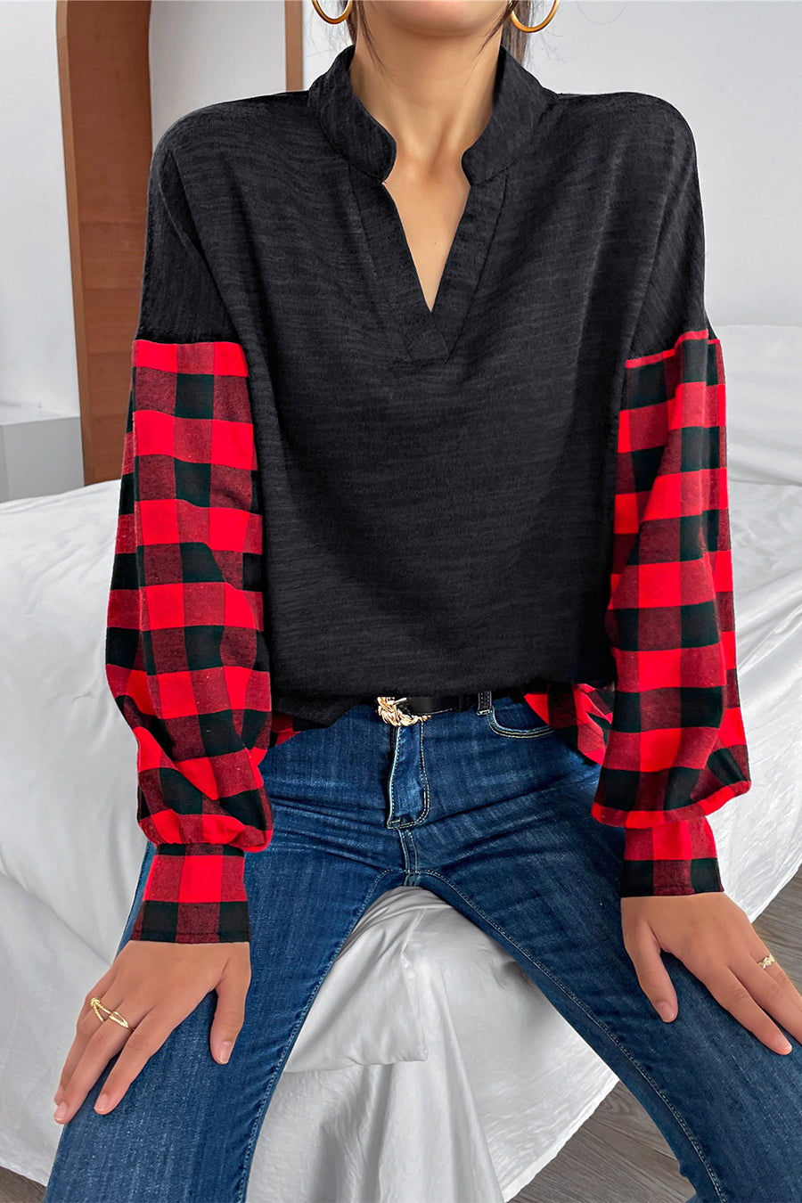 Black henley top with contrast red buffalo plaid balloon sleeves and a V-neck.