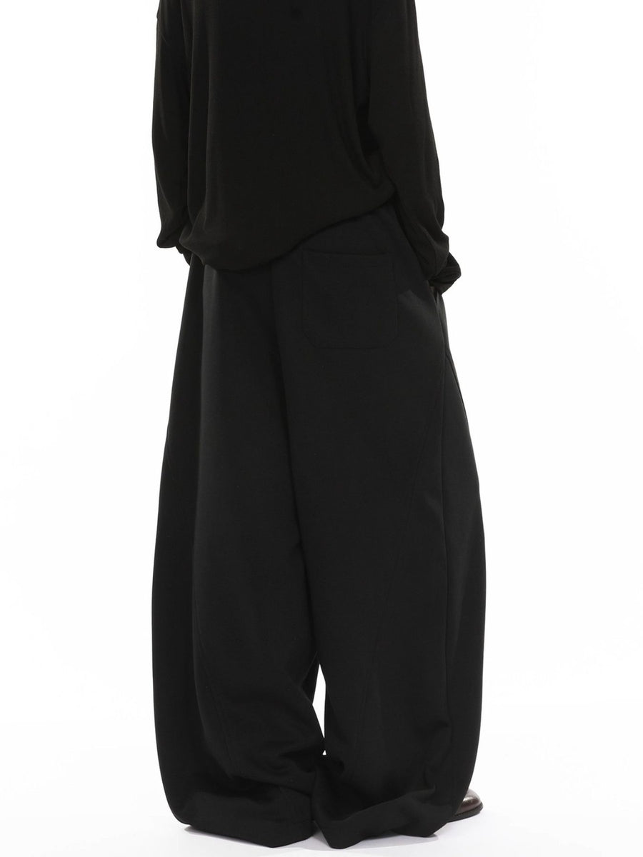 Men's black wide-leg sweatpants with drawstring and back pocket detail.