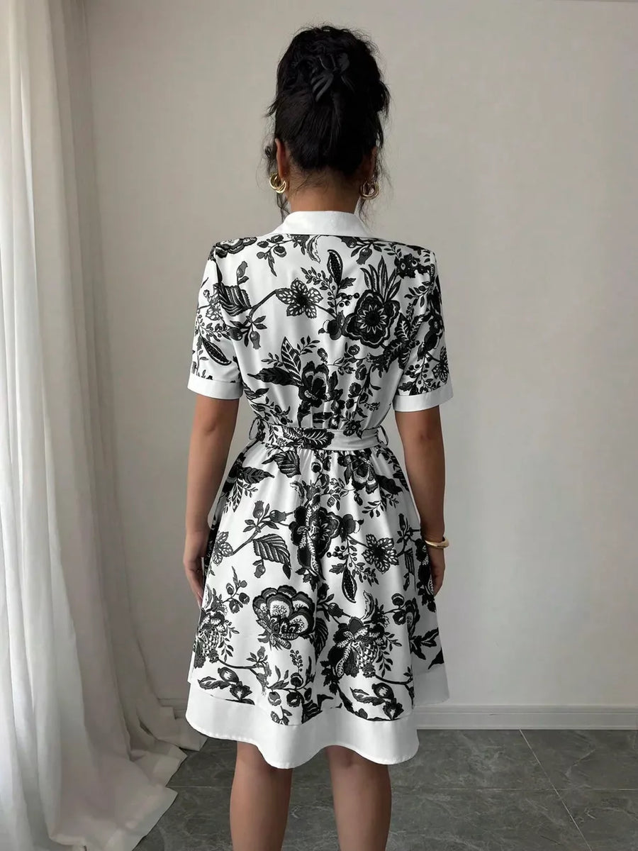 Floral print mini dress with tie belt, short sleeves, and collared neckline.