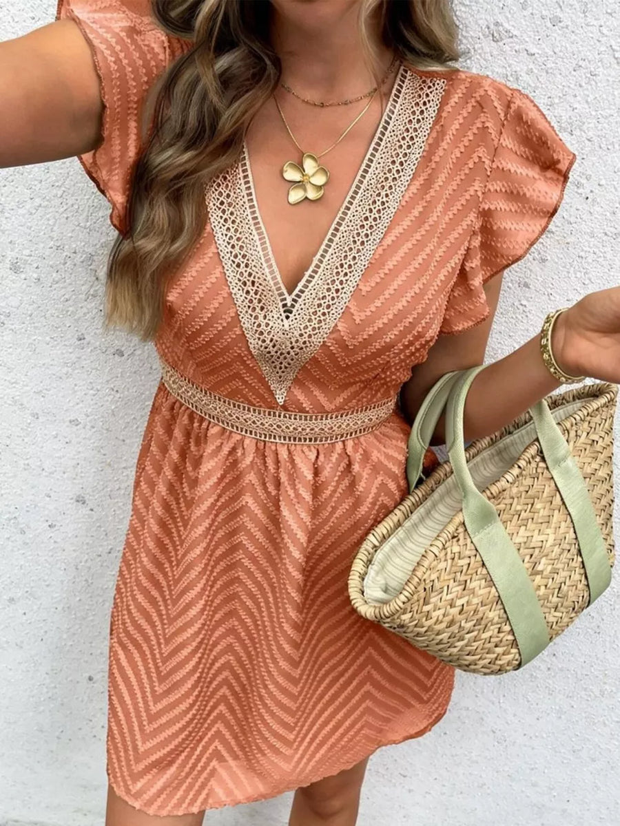 Chevron textured mini dress in burnt coral with V-neck and lace trim.