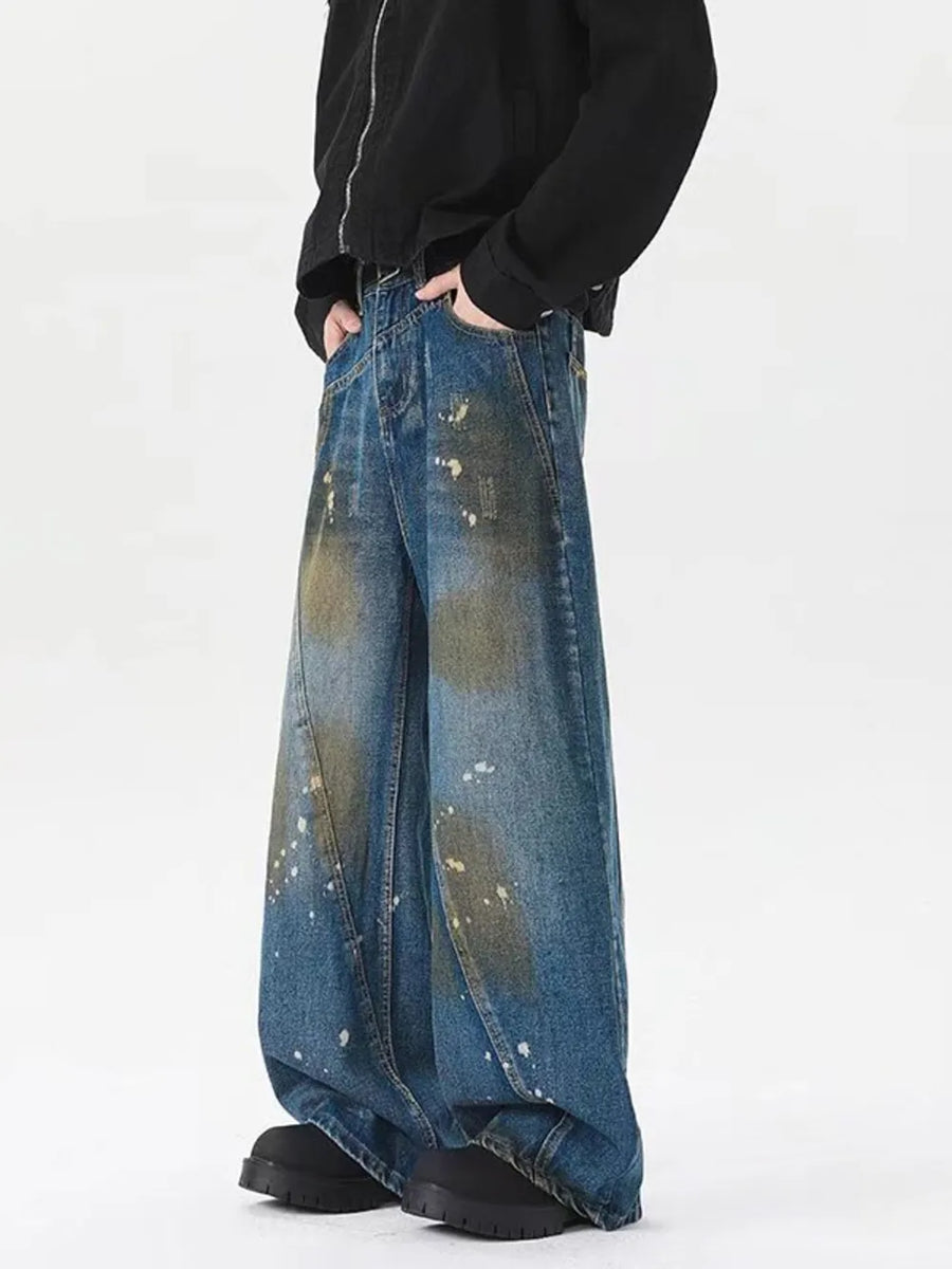 Men's plus-size wide-leg jeans in washed blue denim with paint splatter details.