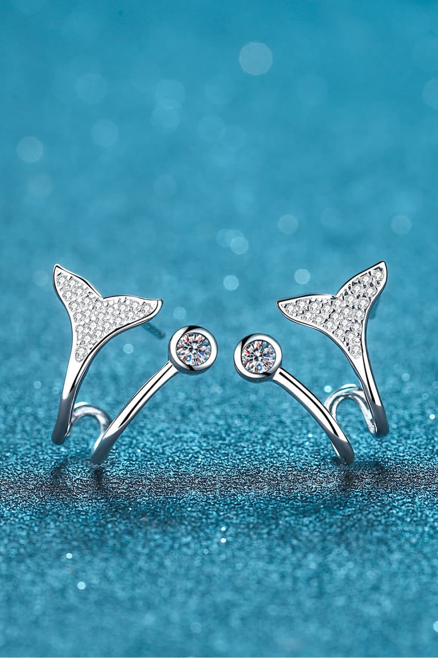 Silver whale tail stud earrings with crystal accents and a round gem stud.