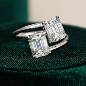 Emerald-cut moissanite bypass ring in silver with two radiant stones.
