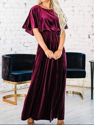 Burgundy velvet maxi dress with flutter sleeves, cinched waist, and round neck.