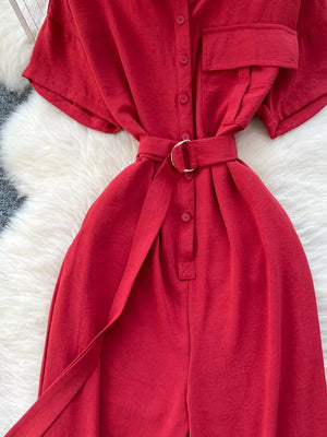 Red belted wide leg romper with button-down front and short sleeves.