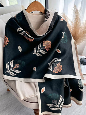 Black floral print fringed shawl with cream border, styled over a cream sweater.