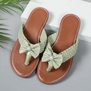Green bow embellished flat thong sandals with woven straps and pearl detail.