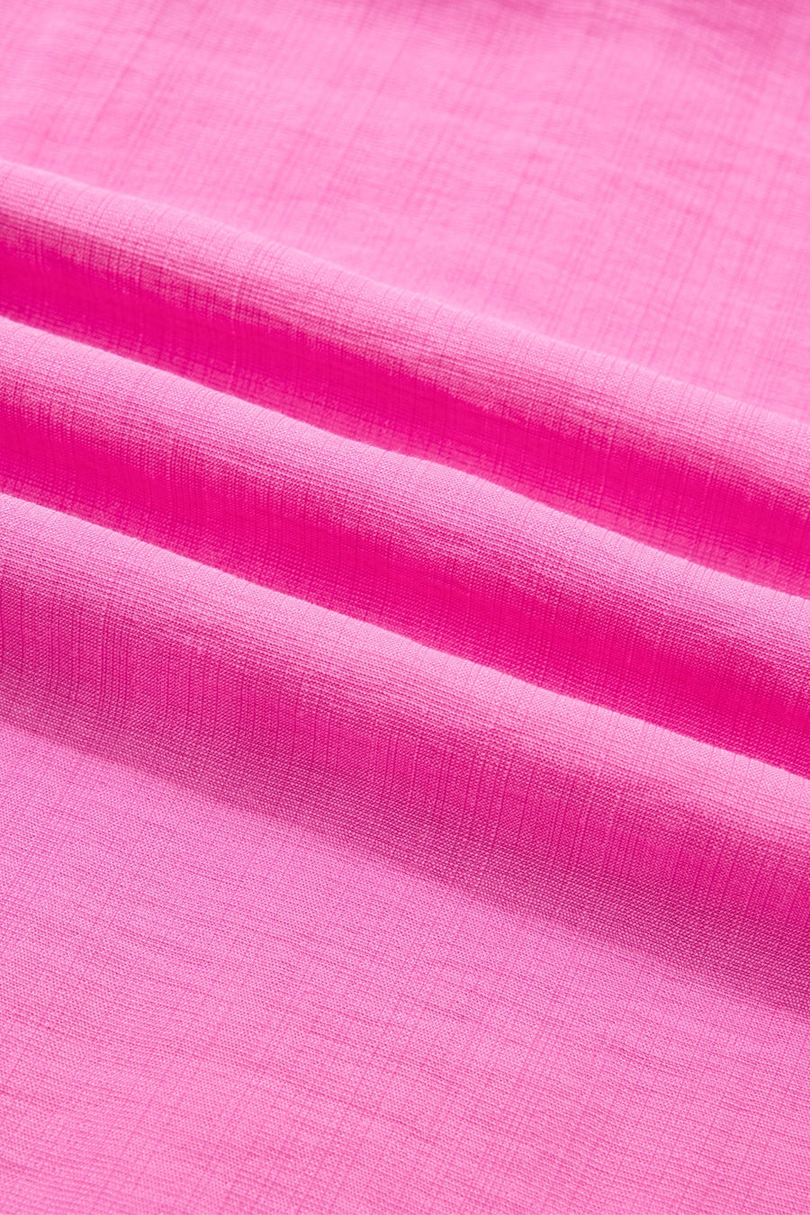 Ruffled sleeveless maxi dress in bright pink textured fabric with smocked waist detail.