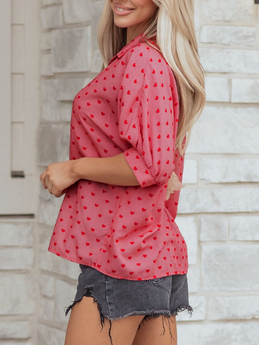 Red button-down shirt with a heart pattern, cuffed sleeves, and classic collar.