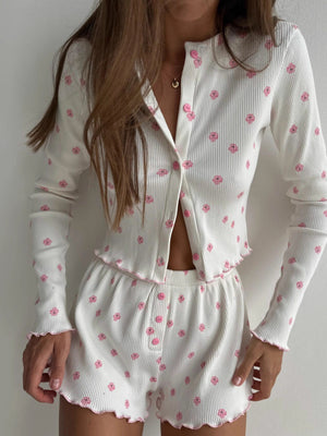 White floral print knit lounge set with button front top and shorts, featuring frill trim.