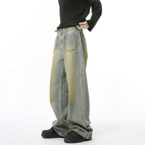 Distressed denim jeans in medium wash with yellowing accents, wide leg, and cotton composition.