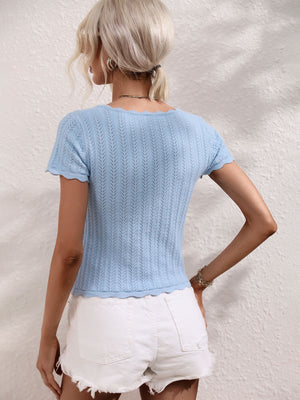 Light blue knit top with scalloped neckline and hem, featuring a textured pattern.