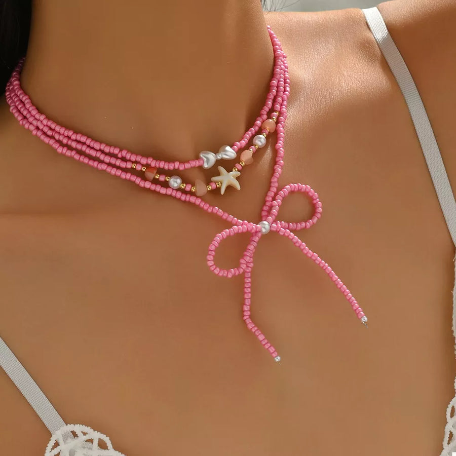 18K Gold-Plated, Alloy, Resin, Millet Pearl Care instructions: Avoid wearing dur necklace in pink with layered silhouette
