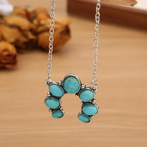 Turquoise horseshoe necklace with silver chain and alloy setting.