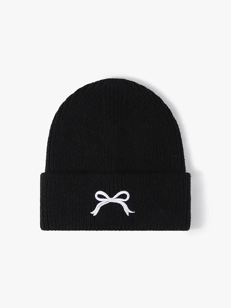 Black ribbed knit beanie with embroidered white bow detail