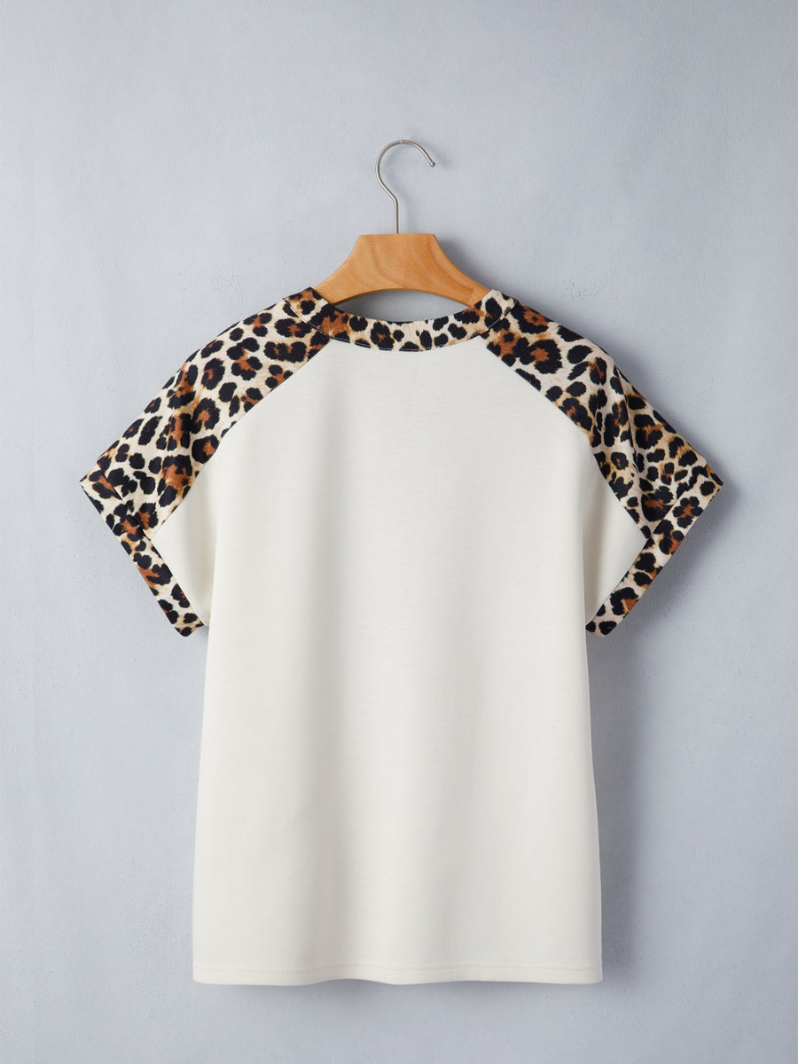 Cream short sleeve blouse with leopard print raglan sleeves and crew neck.