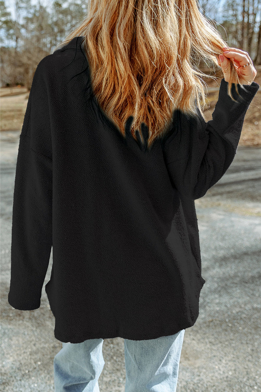 Black button-up coat with textured fabric and pockets