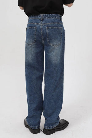 Zip-front relaxed fit denim jeans in medium wash with a baggy cut.