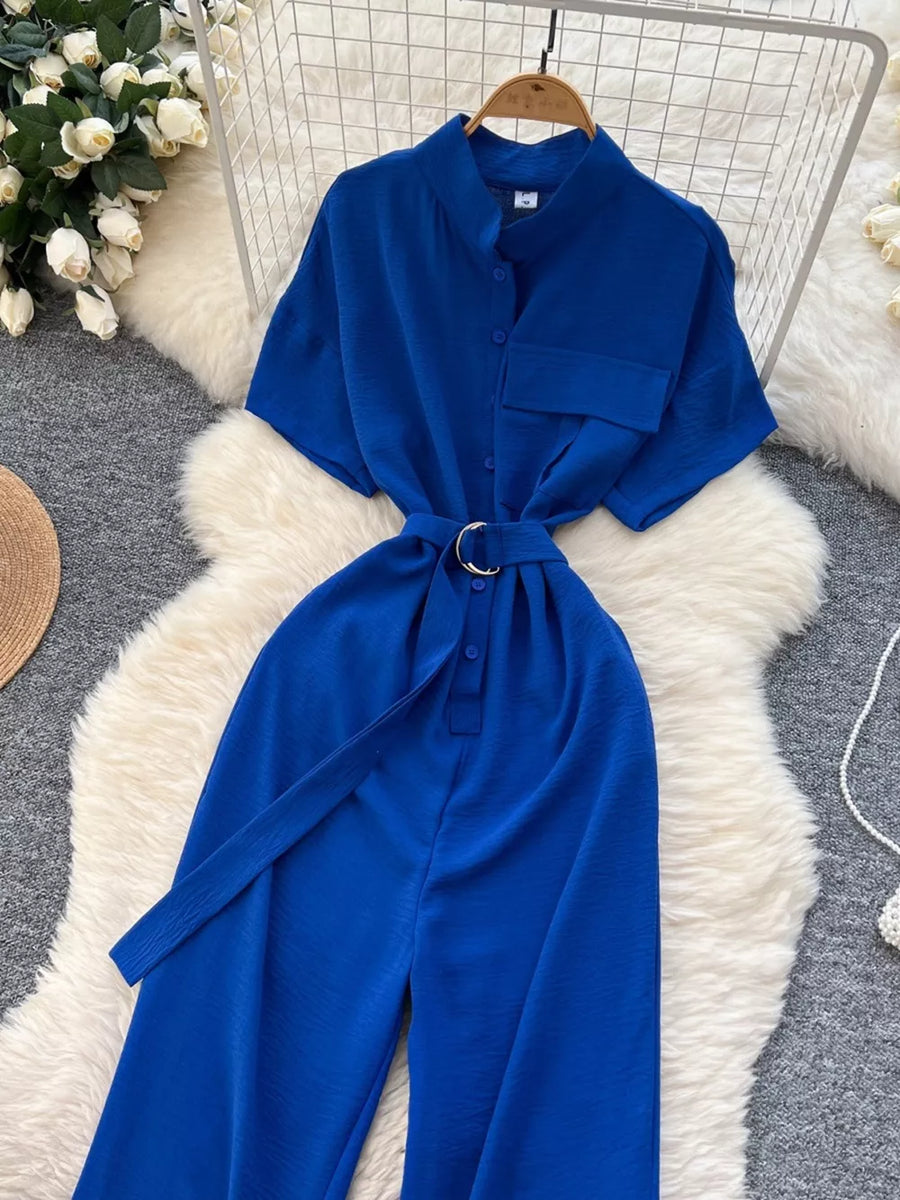 Blue belted wide leg romper with short sleeves and button-down front.
