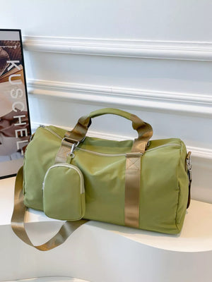 Green duffle bag with detachable pouch and gold straps, perfect for gym or travel.
