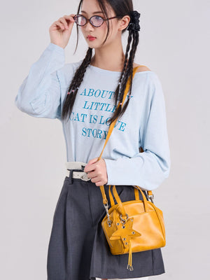 crossbody bag in mustard yellow featuring star charm and structured fit