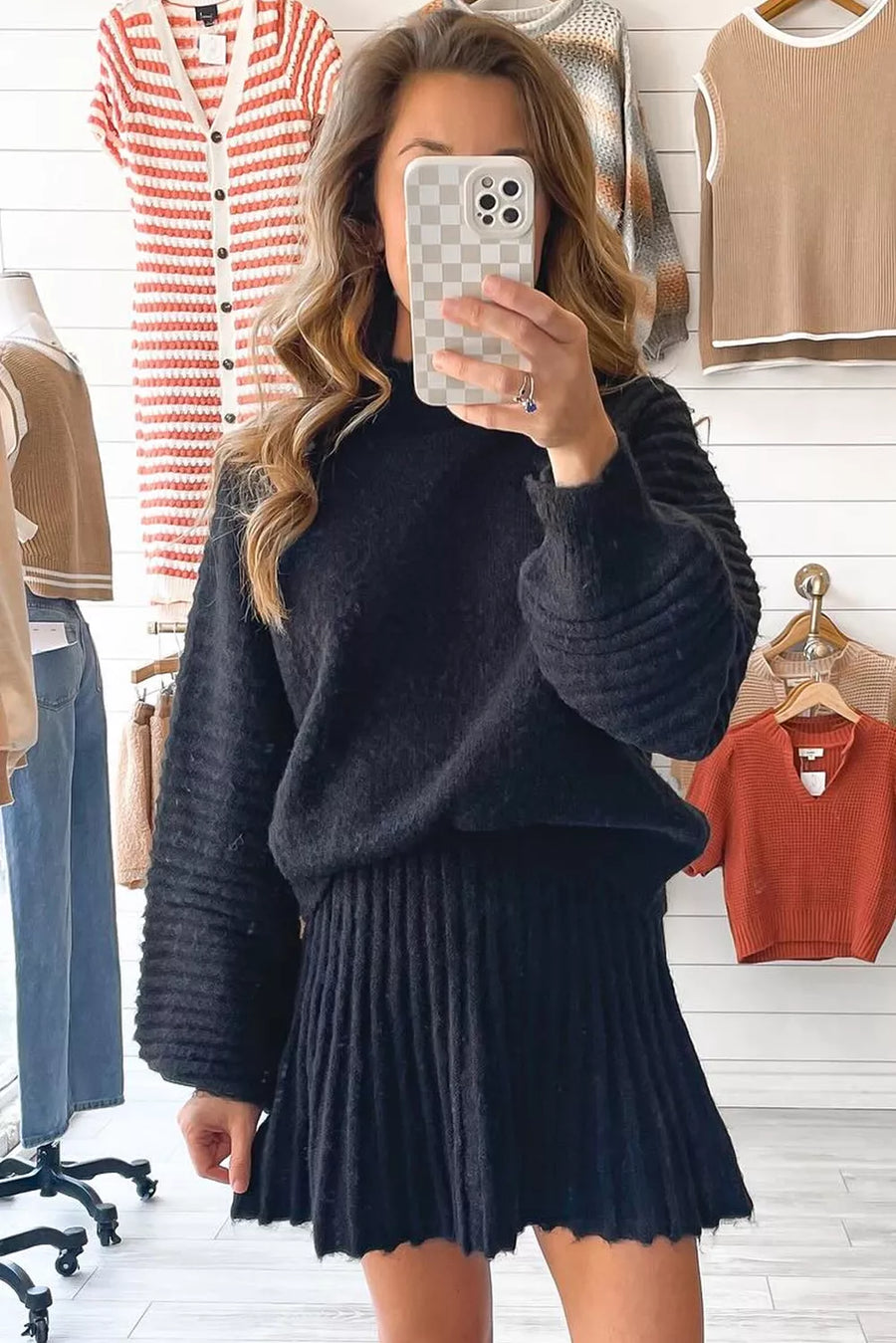 Black acrylic sweater set with balloon sleeves and a pleated mini skirt