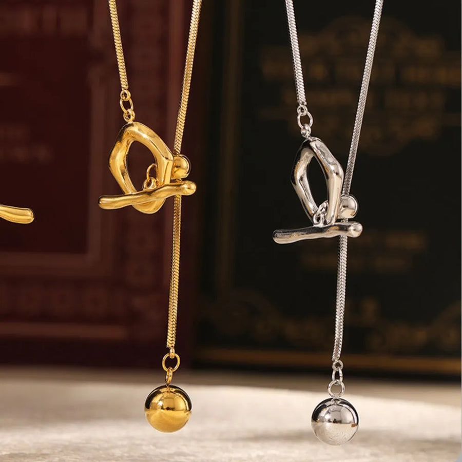 Gold and silver lariat necklaces with a gymnast charm and ball drop