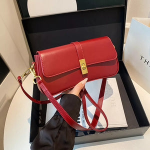 Red rectangular crossbody bag with gold clasp and adjustable strap