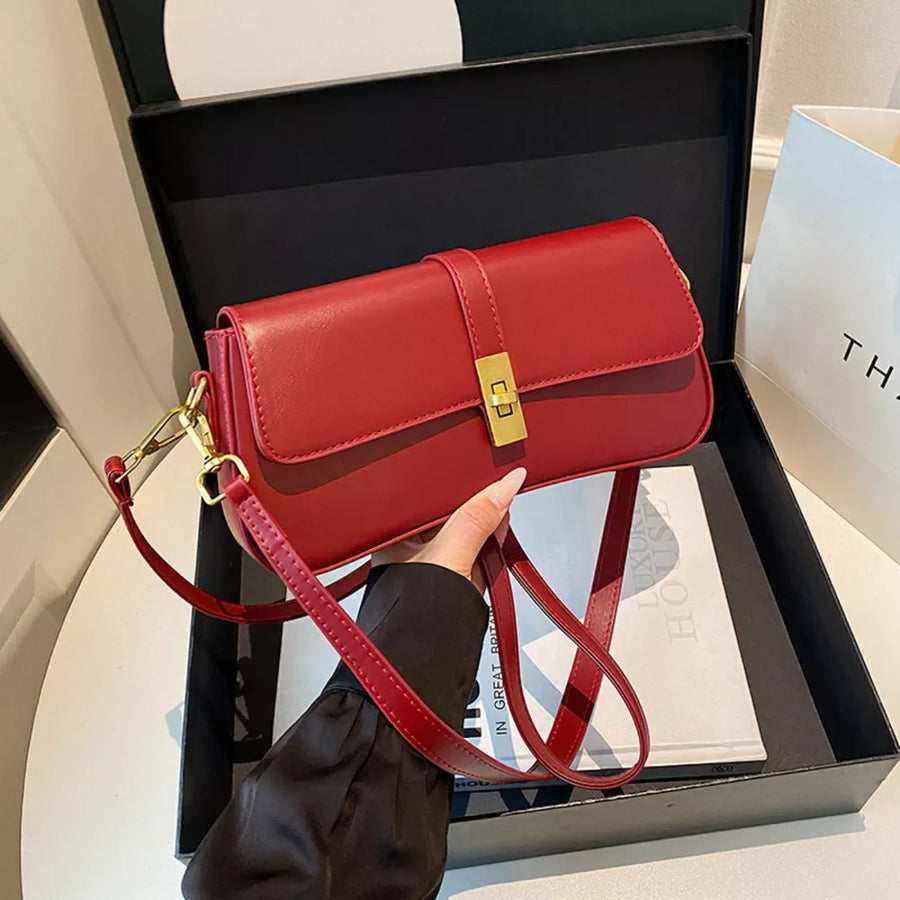 Red rectangular crossbody bag with gold clasp and adjustable strap