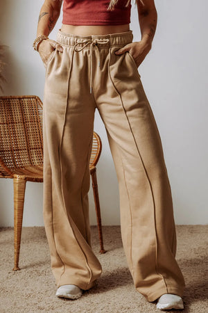 Tan wide-leg sweatpants with relaxed seam details and drawstring waist.