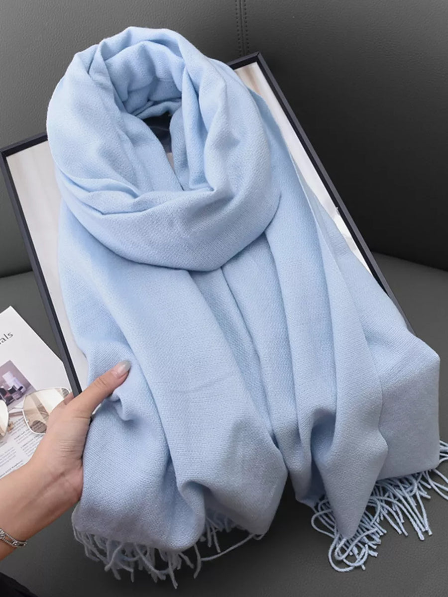 Light blue scarf with fringe detail, soft texture, and elegant drape.