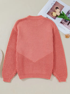 Burnt Coral knit sweater with chevron detail and textured sleeves.