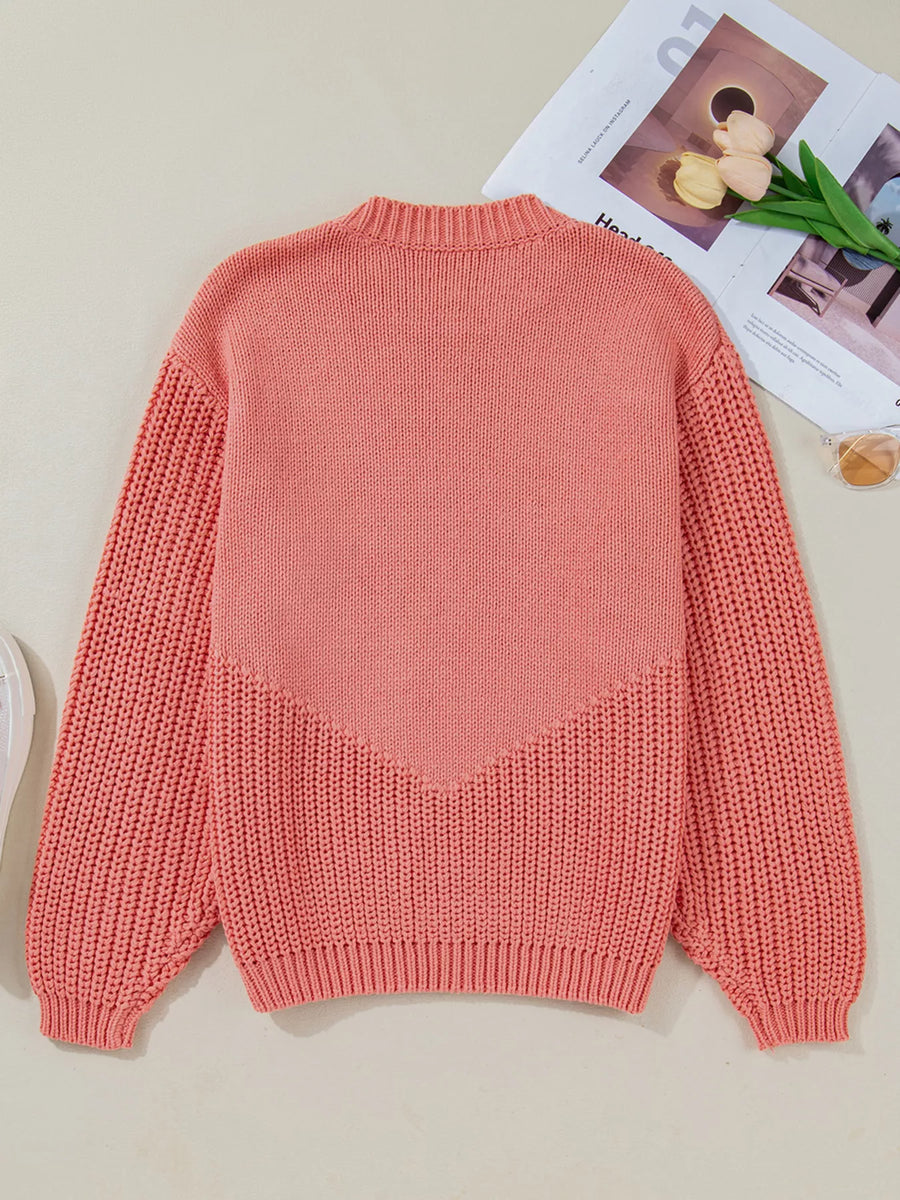 Burnt Coral knit sweater with chevron detail and textured sleeves.
