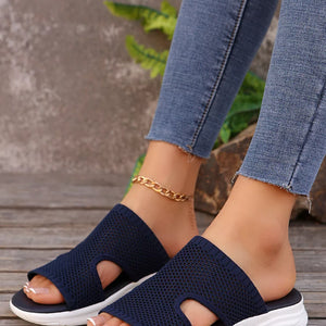 Dark blue open-toe mesh sandals with a white sole and a gold chain anklet.
