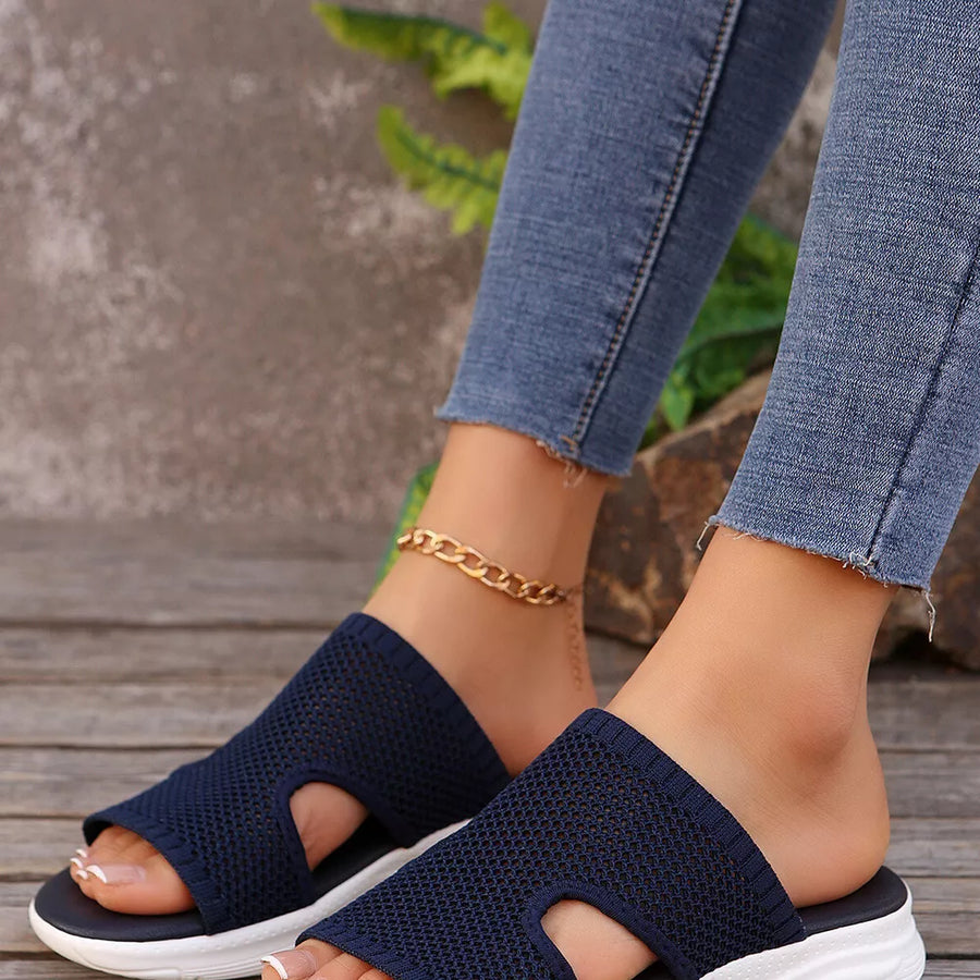 Dark blue open-toe mesh sandals with a white sole and a gold chain anklet.