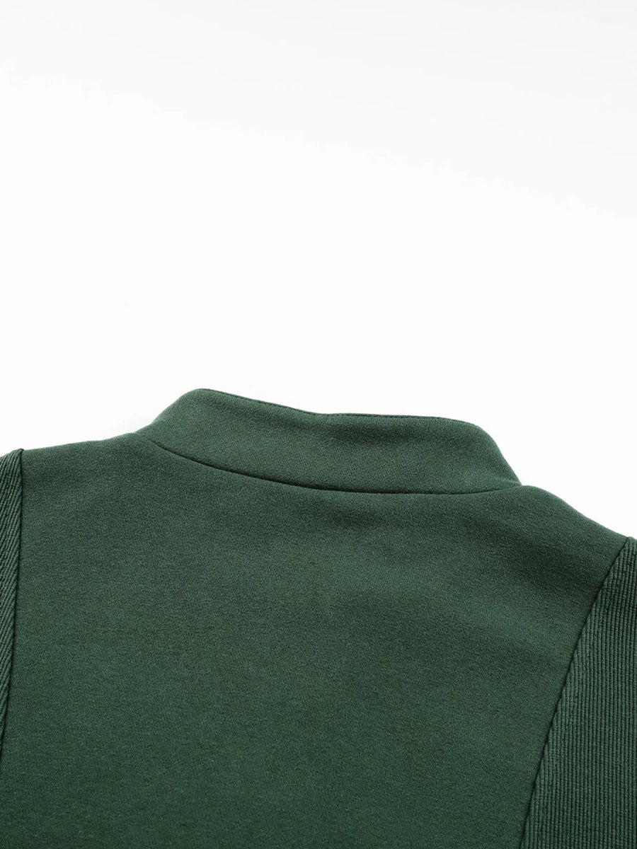Dark green half zip sweatshirt with stand collar and ribbed sleeve detail.