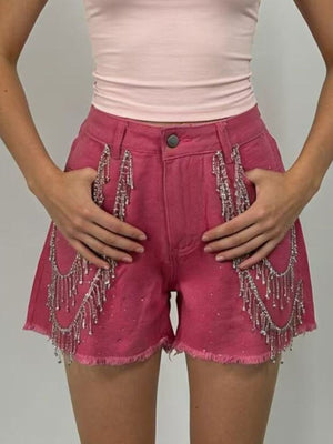 Fuchsia pink denim shorts with rhinestone embellishments and chain fringe detail.