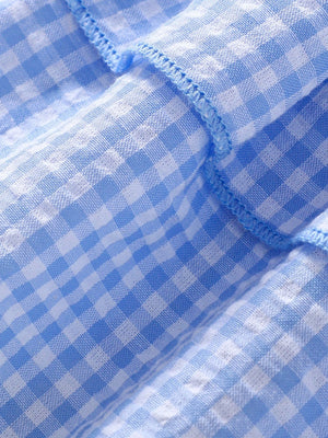 Baby dress in pastel blue gingham cotton blend with ruffled detail.