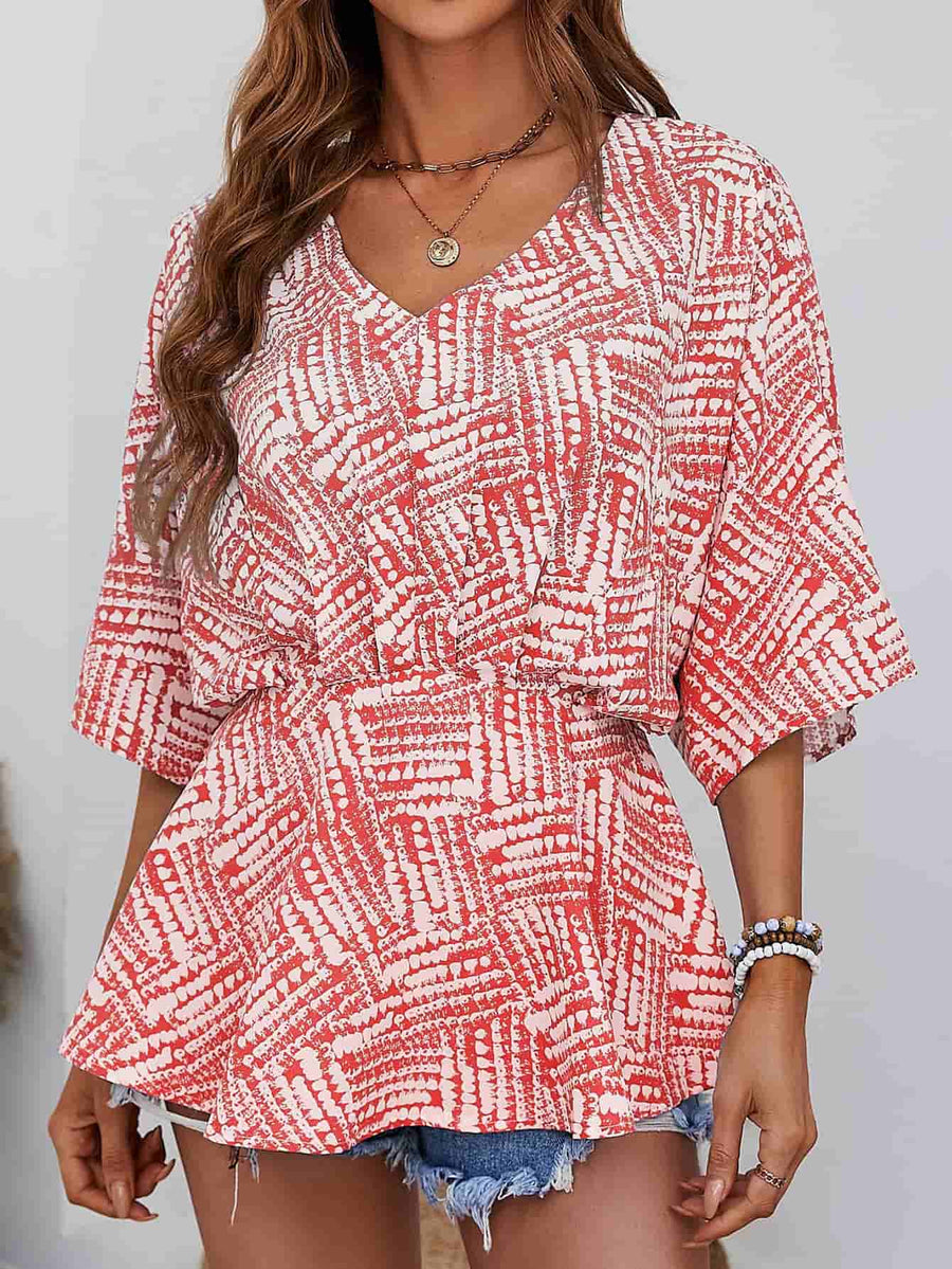 Women's scarlet abstract print cinched waist v-neck blouse with short sleeves.