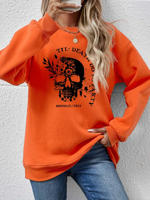 Orange sweatshirt with floral skull graphic and text.
