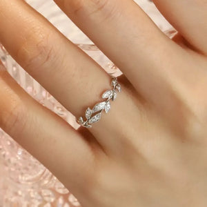 Delicate sterling silver ring with a leaf design and small stones.