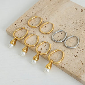 Gold and silver oval hoop earrings with pearl drops.