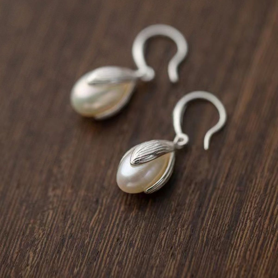 Lustrous pearl drop earrings with silver setting and hook clasps.