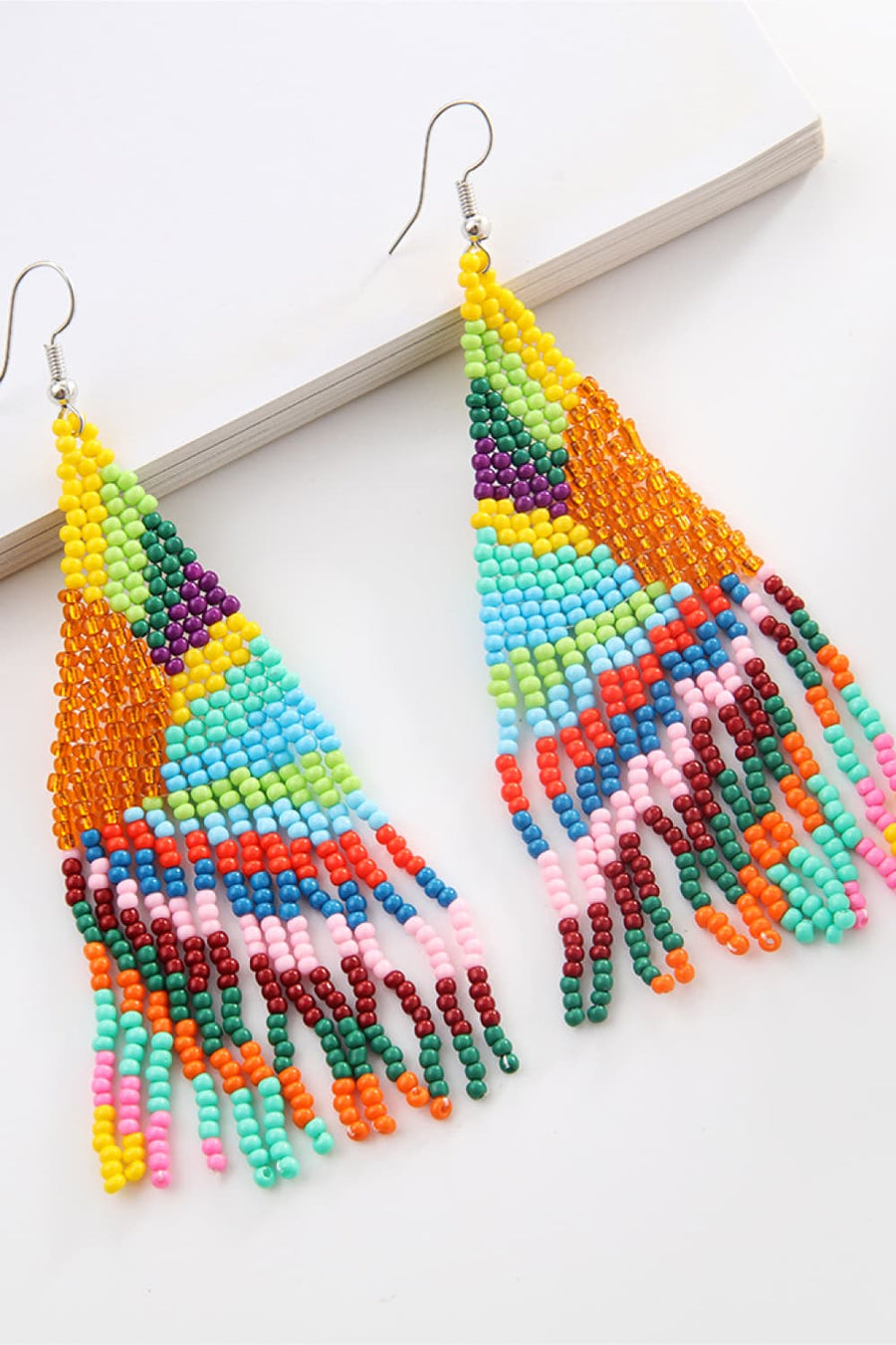 Chic beaded drop earrings in a colorful, geometric pattern with fringe detail.