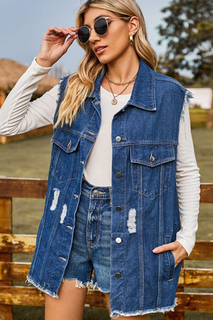 Distressed denim sleeveless jacket in dark wash with frayed hem and distressed details.