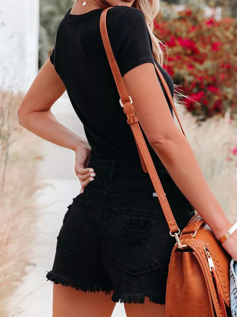Black V-neck maternity t-shirt with short sleeves and button detail, worn with distressed denim shorts.